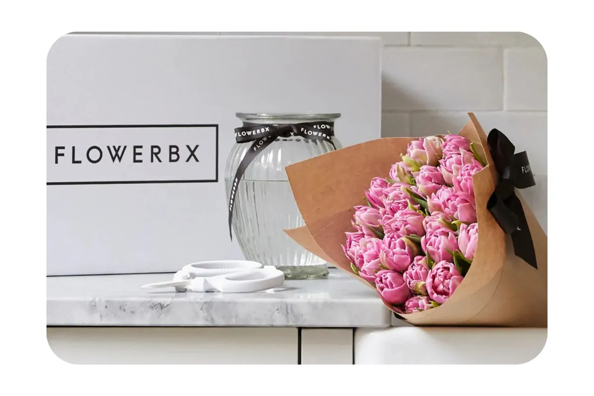 Image shows cut flowers on a work top with scissors and a FLOWERBX box